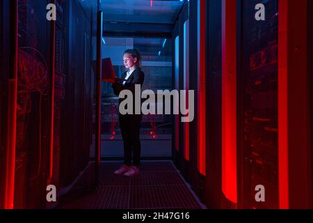 Woman working on servers in data center Stock Photo