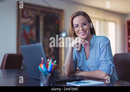 Happy young businesswoman toothy smile at laptop Stock Photo