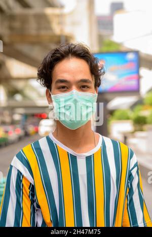 Portrait of handsome young man wearing colorful shirt outdoors during summer Stock Photo