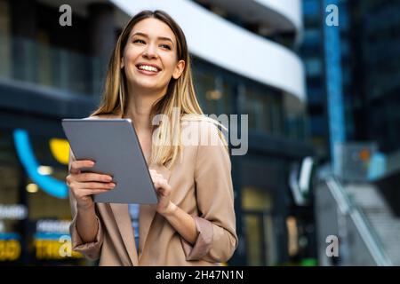Portrait of successful woman using digital tablet in urban background. Business people concept Stock Photo