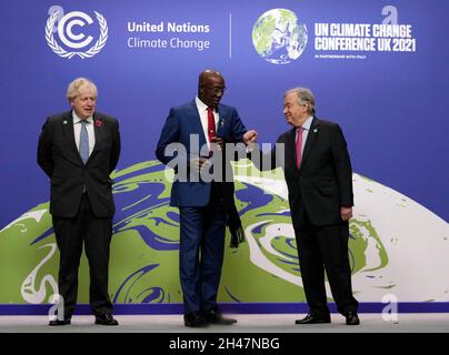 Prime Minister Boris Johnson (left) and United Nations Secretary General Antonio Guterres (right) greet Trinidad and Tobago's Prime Minister Keith Rowley at the Cop26 summit at the Scottish Event Campus (SEC) in Glasgow. Picture date: Monday November 1, 2021. Stock Photo