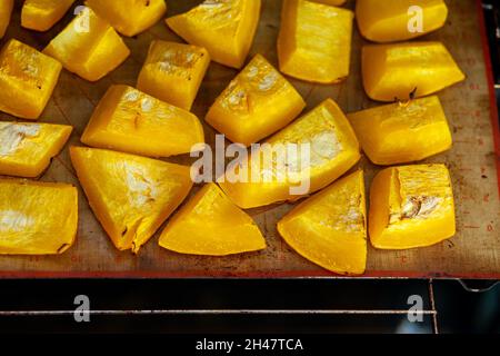 Pumpkin slices baked on a baking sheet in the oven. Homemade food Stock Photo