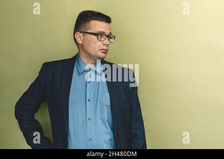 Handsome businessman wearing glasses looking up. the man in the blue suit looks away. Copy space. Stock Photo