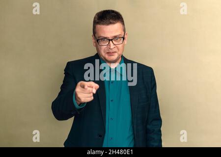 Businessman pointing forward on gray background. man points his index finger forward Stock Photo