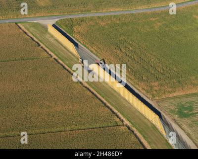 AERIAL VIEW. Corn ears stacked up in a very long crib for natural drying. Sundhoffen, Alsace, Grand Est, France. Stock Photo