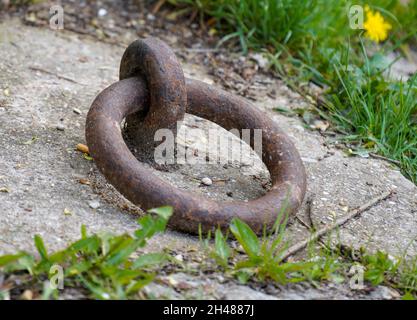 Old iron ring set in concrete for mooring ships in the harbor Stock Photo