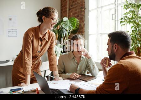 Portrait of creative team using laptop while discussing design project in studio, copy space Stock Photo