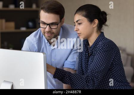 Focused millennial mixed race employees working on computer. Stock Photo