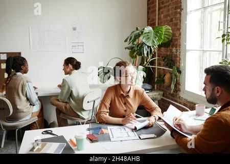 Portrait of diverse creative team working in modern studio lit by sunlight, copy space Stock Photo