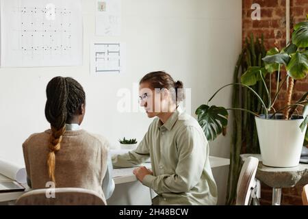 Portrait of two creative young people working on design project in minimal studio, copy space Stock Photo