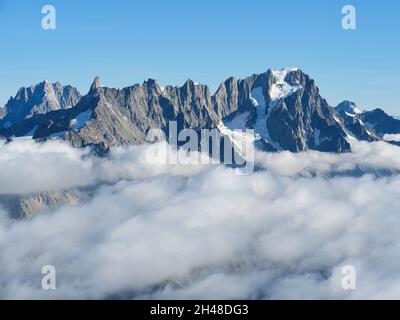 AERIAL VIEW. Southeastern face of Aiguille du Géant and the Grandes Jorasses above a sea of clouds. Val Ferret, Courmayeur, Aosta Valley, Italy. Stock Photo