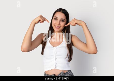 Young brunette woman is pointing her self. A gesture for using as marketing. High quality photo Stock Photo