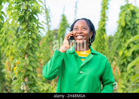 Shot of a happy female African farmer in Nigeria making a phone call Stock Photo