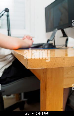 A young gamer with headphones boy playing a computer game on a powerful desktop computer Model Release Available Stock Photo