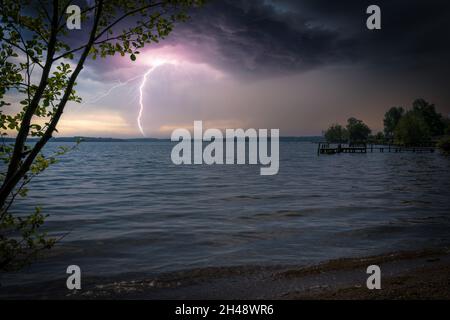 lightning from a thunderstorm strikes a lake Stock Photo