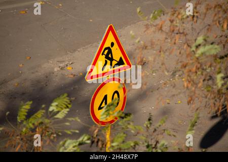 Road sign and symbol. Traffic sign on the background of the street. Road signs. Road repair and speed limit for cars. Driver warning sign for safe dri Stock Photo
