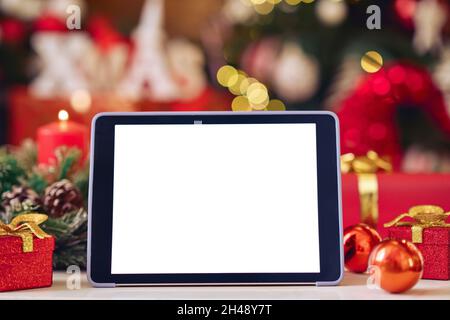Digital tablet mockup white blank screen for ads on Christmas table background. Stock Photo