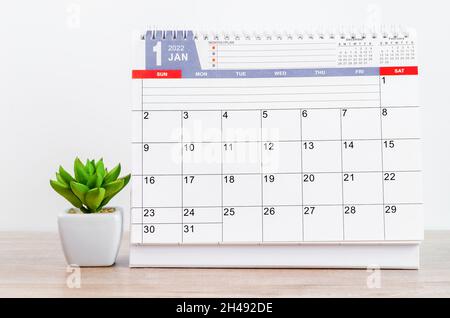 The January 2022 desk calendar on wooden table. Stock Photo