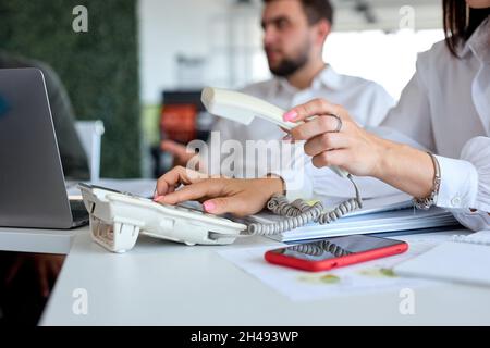 Side view cropped photo of business woman operator wearing formal wear using landline phone, dialing voip phone in office, copy space. close-up photo Stock Photo
