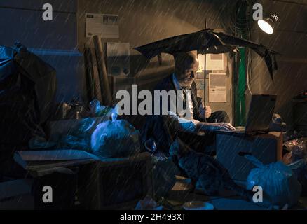 Broke homeless businessman sitting on the street under the rain, he has ...