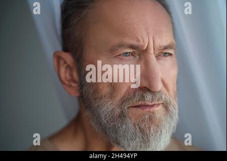 Low-spirited handsome Caucasian man lost in thought Stock Photo