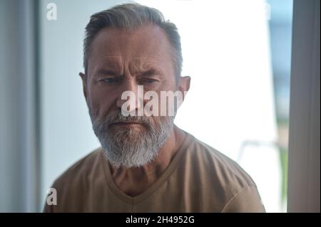 Dejected bearded mature male lost in thought Stock Photo