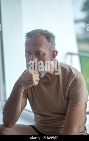 Pensive man sitting alone in a room Stock Photo