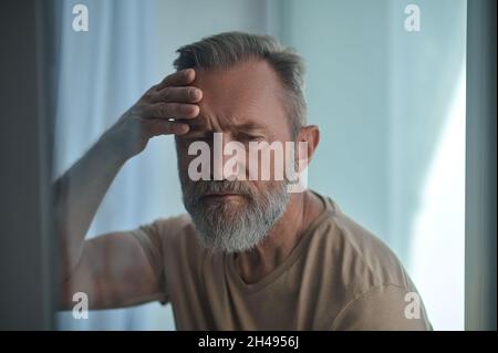 Mature Caucasian male feeling concerned about something Stock Photo
