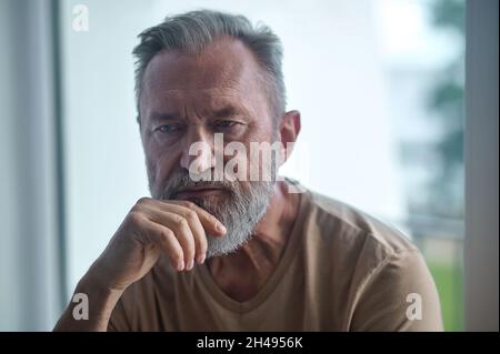 Thoughtful lonely man sitting in a room Stock Photo