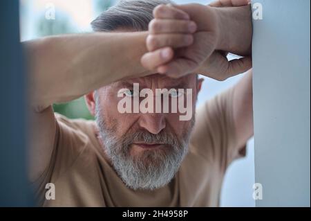 Gloomy blue-eyed Caucasian man pondering over something Stock Photo