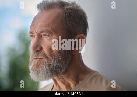 Sad gray-headed Caucasian man absorbed in thought Stock Photo