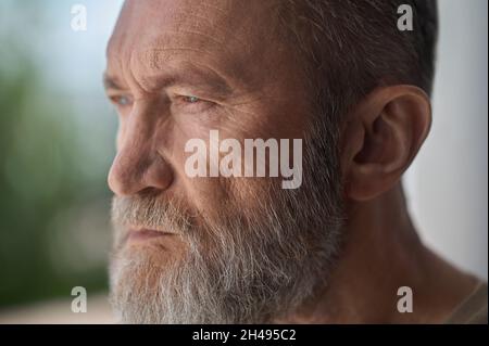 Serious gray-headed man staring into the distance Stock Photo