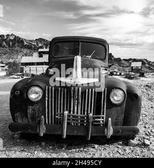 Closeup shot of an old truck in a desert in grayscale Stock Photo