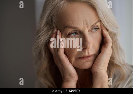 Sad mature woman suffering from a headache Stock Photo