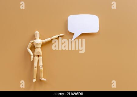 Wooden man figure presenting and showing on speech bubble banner Stock Photo