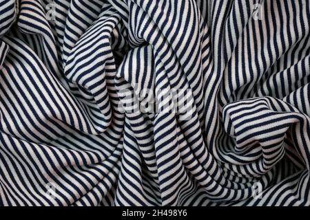 Pleats in striped jersey top view. Draped fabric in black and white striped background. T-shirt texture made of polyester and cotton. Striped jersey s Stock Photo