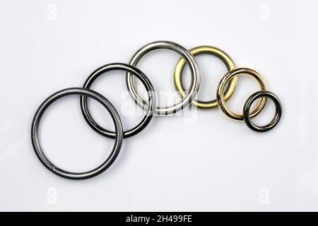 High quality sewing accessories. Large and small metal rings on a white background. Metallic black and gray chrome rings for making bags and backpacks Stock Photo