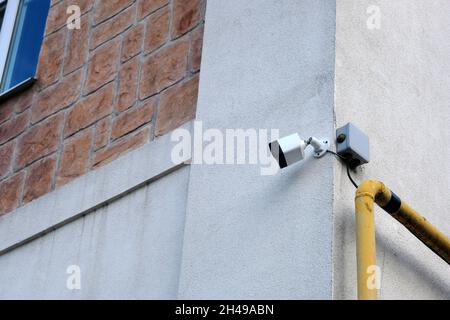 Video surveillance system on the old brick building. White Security Camera, CCTV on location. Stock Photo