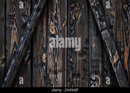 Wooden planks of dark brown color close-up. The texture of the wooden surface. Burnt boards vertical and diagonal background. Dark wood texture, weath Stock Photo