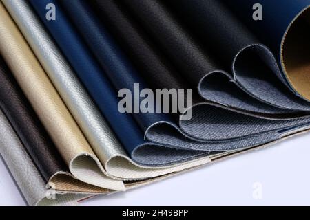 Samples of leatherette in different shades top view. Artificial leather color palette catalog. Eco leather in blue, black, white, background. Dark sha Stock Photo