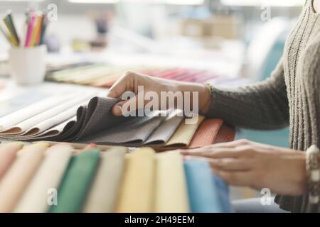 Professional decorator picking fabric swatches for her project, hands close up Stock Photo