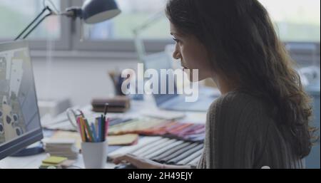 Woman sitting at desk and working on a interior design project Stock Photo