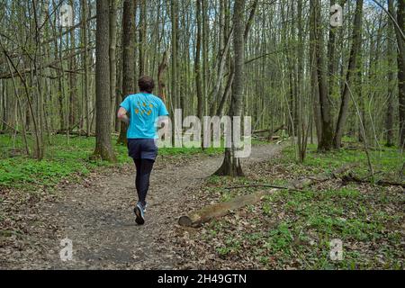 Middle-aged Caucasian man runs along the trail in Bitsevski Park (Bitsa Park). Moscow, Russia. Stock Photo