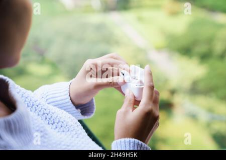 earbuds headphone in female hand, new headphone technology Stock Photo