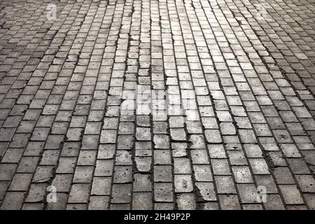 Stone pavement texture, cobbled street. Old road from tiles in sunlight Stock Photo