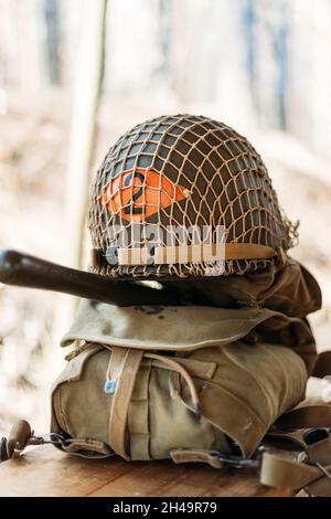 Metal Helmet Of United States Army Infantry Soldier At World War II. Helmet On Camping Tent In Forest Camp Stock Photo