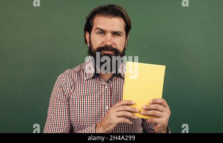 handsome mature college man holding book, literature Stock Photo