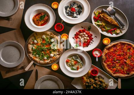 Top down view on enormous buffet of delicious freshly prepared european cuisine and pizza with menu Stock Photo