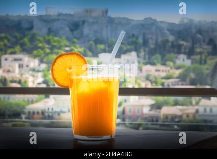 Glass of fresh orange juice on the table outdoors. Stock Photo