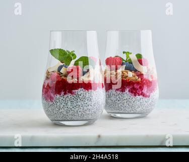Chia seeds, yoghurt, raspberries, blueberries, granola, almond, mint. Superfood parfait in glass Stock Photo